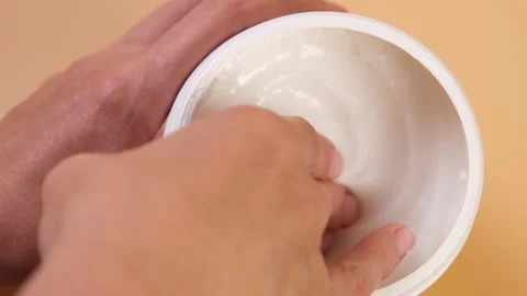 Close-up of a womans hands scooping a hair mask or conditioner from a jar. Stock Footage 318954853