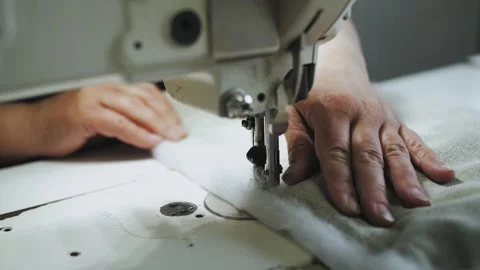 Close-up woman's hands sewing fabric on the automatic sewing machine. Seamstress Stock Footage 260460749
