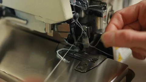 Close-up of woman's hands sewing an overlock at sewing machine. Stockbeeldmateriaal 90072571