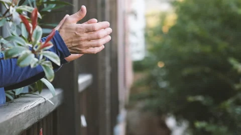 A close-up of a woman's hands as she applauds from her balcony Stock Footage 140343779