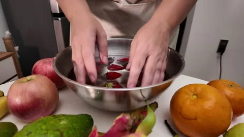 Close-up of a womans hands , standing in front of a table with fruit and washing Stock Footage 319118854