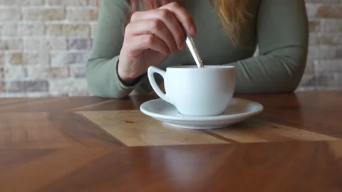 Close-up of a woman's hands stirring a white coffee cup Stock Footage 264884959