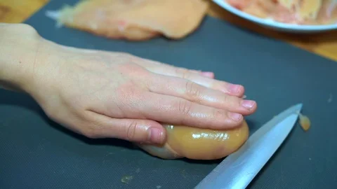 Close up, a woman's hands take a knife and cut the chicken  Stock Footage 106759629