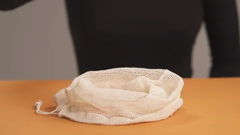 Close-up of woman's hands taking chilies and putting them into cotton pouch mesh Stock Footage 118313325