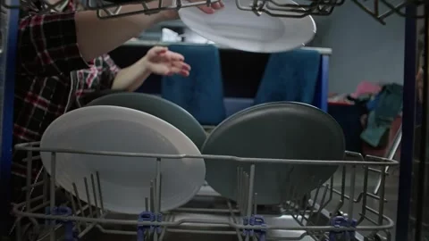 Close-up of womans hands taking clean plates with dishes out of the dishwasher Stock Footage 309054485