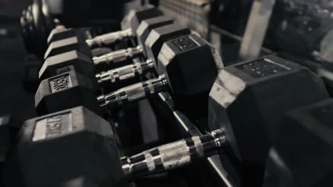 Close-up of a woman's hands taking dumbbells from a shelf. Stock Footage 306814841