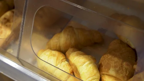 Close-up of a woman's hands taking freshly baked croissants at a bakery. Stock Footage 211102290