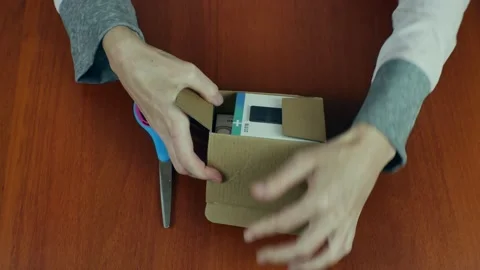 Close-up of a woman's hands taking out three small boxes of goods bought on the Stock Footage 221208937