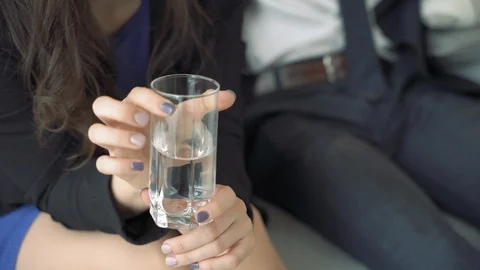 Close-up of a woman's hands tapping her fingers on a glass of water. Stock Footage 119598399