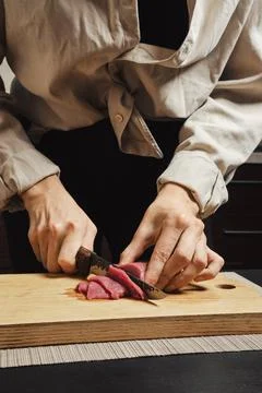 Close-up of woman's hands thinly slicing raw meat for Korean barbecue Stock-Fotos