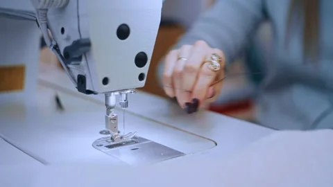 Close-Up of a Woman's Hands Threading the Needle of a Sewing Machine in a Stock Footage 335931762