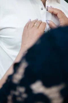 Close-up of a woman's hands touching a man's white shirt, Foto stock