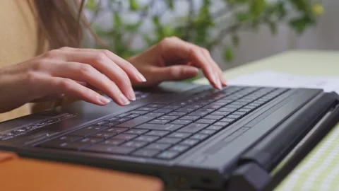 Close up on woman's hands typing on black computer board, side view of laptop  Stock Footage 149510800