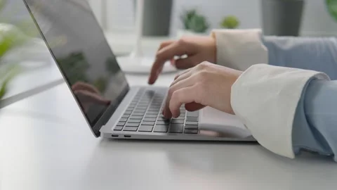 Close-up of a woman's hands typing on a laptop keyboard in a stylish and Stock Footage 260604922