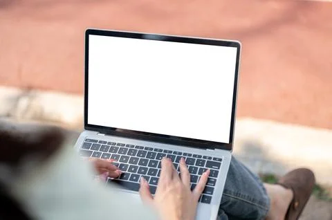 Close up of a woman's hands typing on white screen laptop while sitting on .. Fotos Stock