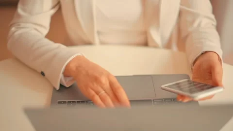 Close up of woman's hands using laptop touchpad and holding smartphone with.. Stock Footage 339412443