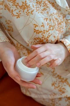 Close up of woman's hands using skin care cream in daily life at home. Skin c Stock Photos