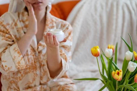 Close up of woman's hands using skin care cream in daily life at home. Skin c Stock Photos