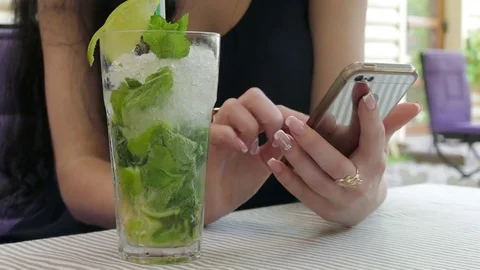 Close Up Of A Woman's Hands Using A Smartphone And Drinking A Cocktail Stock Footage 76641526