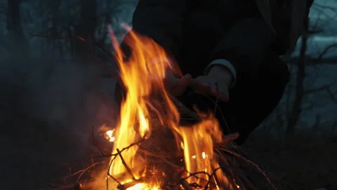 Close-up of a woman's hands warming themselves at dusk by a campfire in nature. Stock Footage 321174565