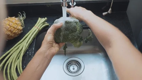Close-up woman's hands washing broccoli at domestic kitchen Stock Footage 89938181