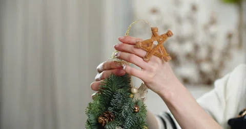 Close-up of a woman's hands, which decorates the Christmas tree and hangs up a Stock Footage 166841193