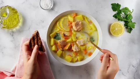 Close up of woman's hands while eating delicious salmon cream soup Stock Footage 138377862