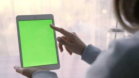 Close-up of a woman's hands working on green screen on a tablet pc. 库存影片 93298802