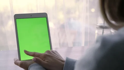 Close-up of a woman's hands working on green screen on a tablet pc Stock Footage 93298821