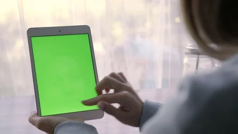 Close-up of a woman's hands working on green screen on a tablet pc Stock Footage 93298855