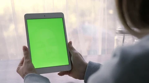 Close-up of a woman's hands working on green screen on a tablet pc Stock Footage 93298862