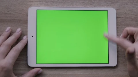 Close-up of a woman's hands working on green screen on a tablet pc Stock Footage 93298925