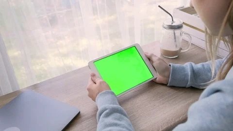 Close-up of a woman's hands working on green screen on a tablet pc Stock Footage 93299222