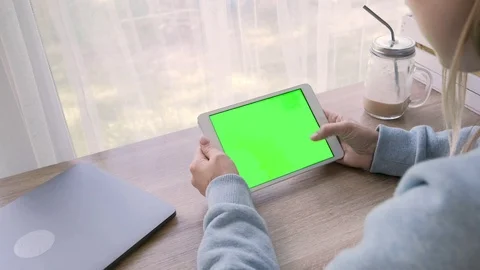 Close-up of a woman's hands working on green screen on a tablet pc Stock Footage 93299241