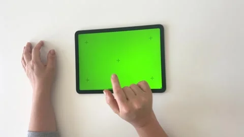 Close-up a woman's hands working on green screen on tablet top view Stock Footage 274683064