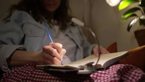 Close-up of a womans hands writing personal thoughts in a diary with a pen at Stock Footage 322513831