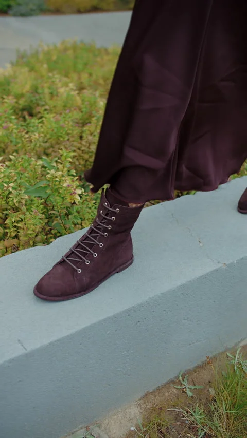 Close-up of womans lace-up boot stepping on concrete edge outdoors Stock Footage 320787978