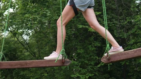Close-up of a womans legs on swaying logs. Rope park and zipline Stock Footage 281222078