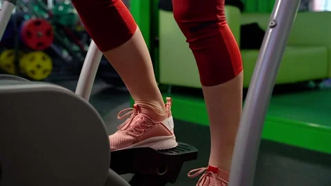 Close-up of woman's legs using stair stepper while having cardio workout in gym Stock Footage 101010047