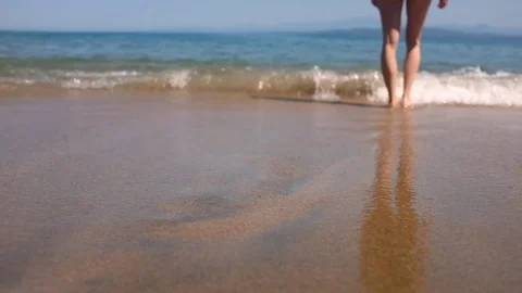 Close-up on woman's legs walking into an ocean at tropical sandy beach 库存影片 74503624