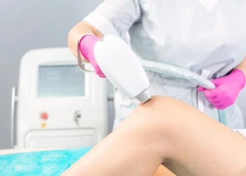 Close-up woman's legs while getting hair removal procedure in salon Stock Photos