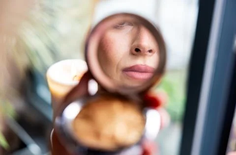 Close-up of a woman's lips reflected in a make-up compact Foto stock