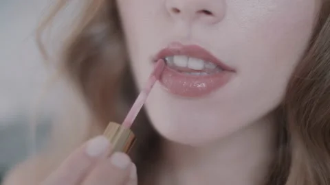 Close up of woman's lips while she's putting on lip gloss Stock Footage 131067548