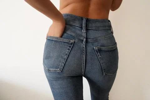 Close-up of womans midsection in high-waisted jeans, casual fashion Stock Photos
