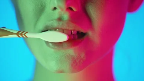 Close-Up Of Woman's Mouth Brushing Teeth With Toothbrush, Colorful Studio Stock Footage 295363573