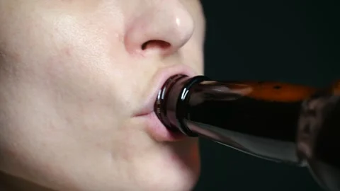 Close up of a womans mouth drinking beer from a bottle Stock Footage 321736161