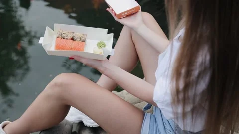 Close up of womans opening sushi roll takeaway box. Advert for sushi delivery Stock Footage 151417511