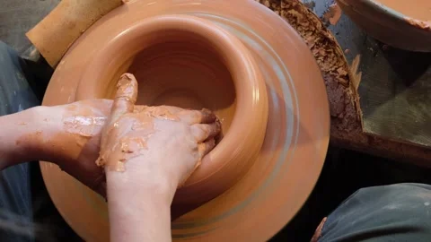 Close-up of a woman's potter's hands creating a bowl on a footed old circle. For Stock Footage 220076865