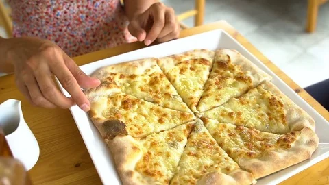 Close up of women taking cheese pizza slices from small plate Stock Footage