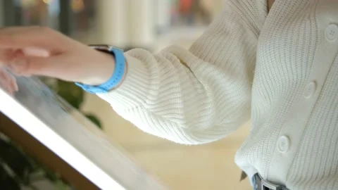 Close-up. Women using a touch terminal in a shopping mall to search for the Stock Footage 239429710
